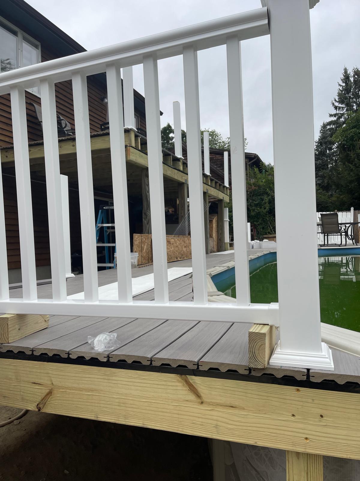 White vinyl railing installation on composite deck